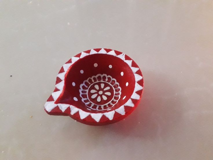 a red and white bowl sitting on top of a table