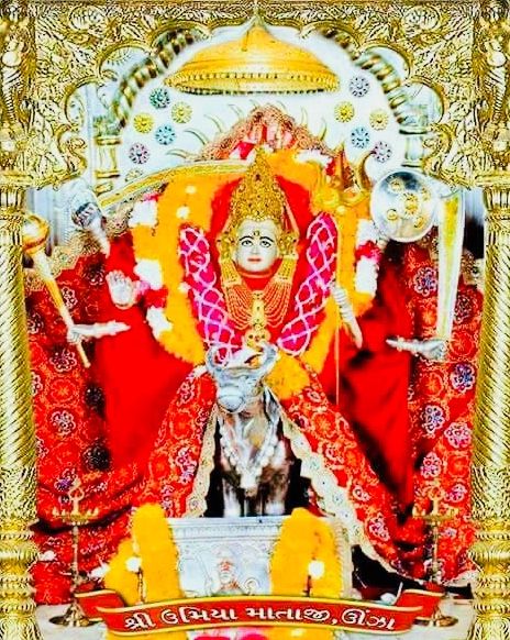 an idol is displayed in front of a gold frame with red and yellow decorations on it