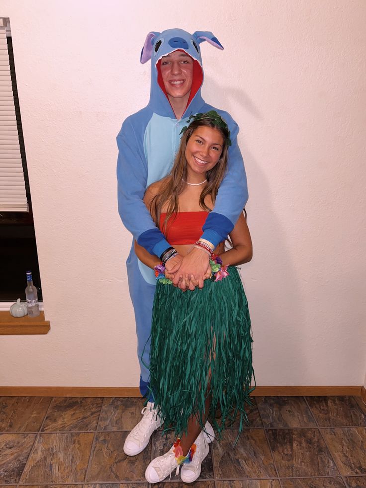 two people dressed up in costumes standing next to each other on the floor with their hands together