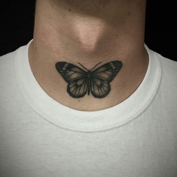 a black and white butterfly tattoo on the neck