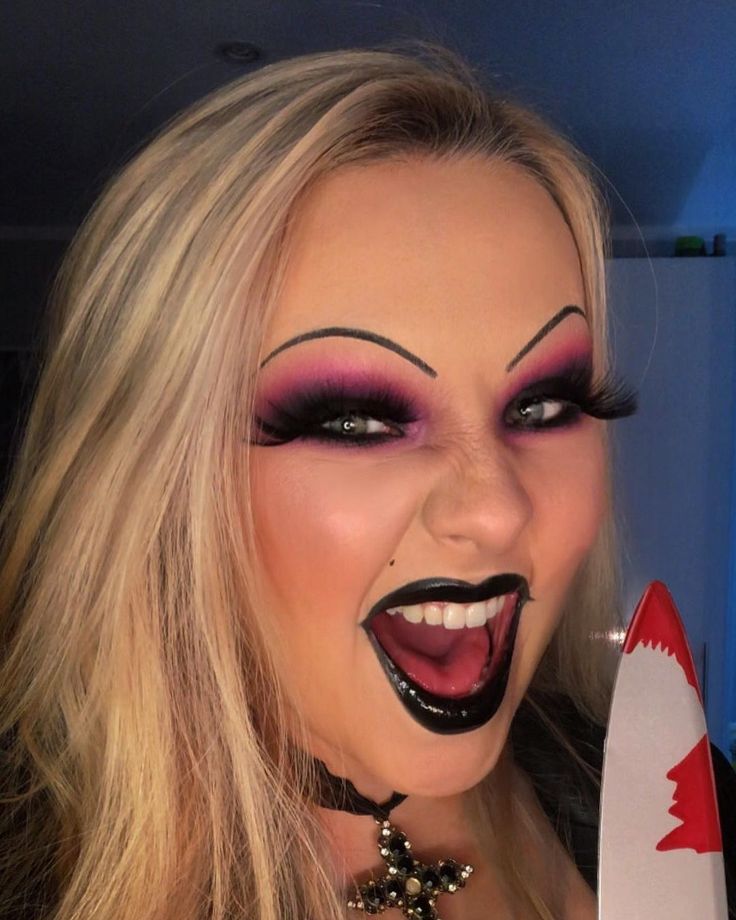 a woman with makeup on holding a knife