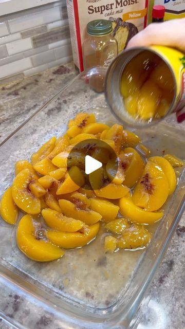 someone is pouring orange juice into a glass container filled with sliced peaches and other ingredients