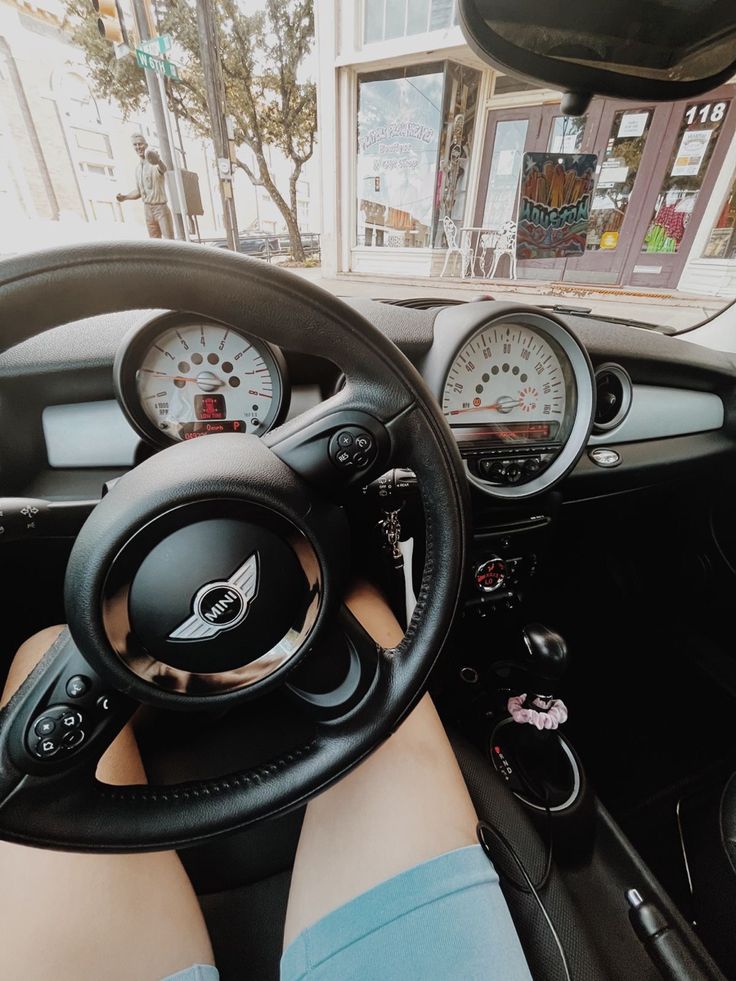 a person is sitting in the driver's seat of a car with their feet on the steering wheel