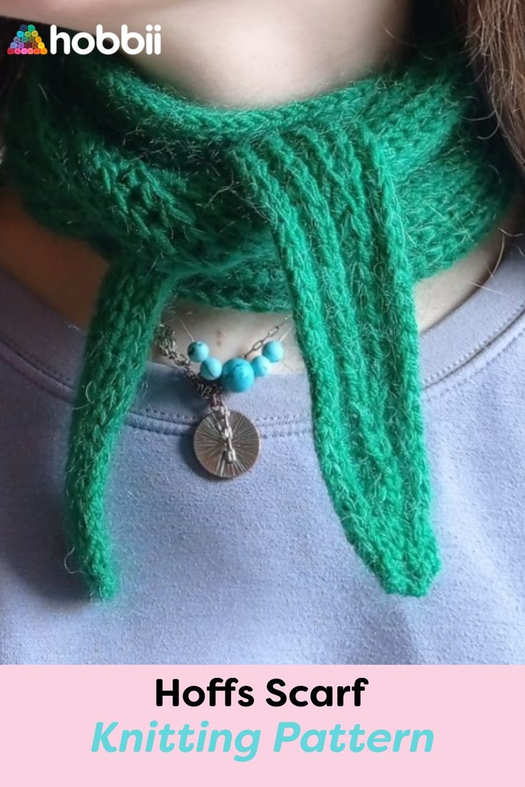 a woman wearing a green knitted scarf with a charm on it's neck