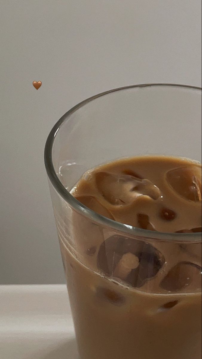 a glass filled with liquid sitting on top of a table