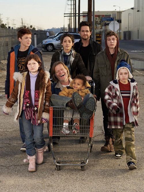 a group of people standing next to each other in front of a shopping cart on the street