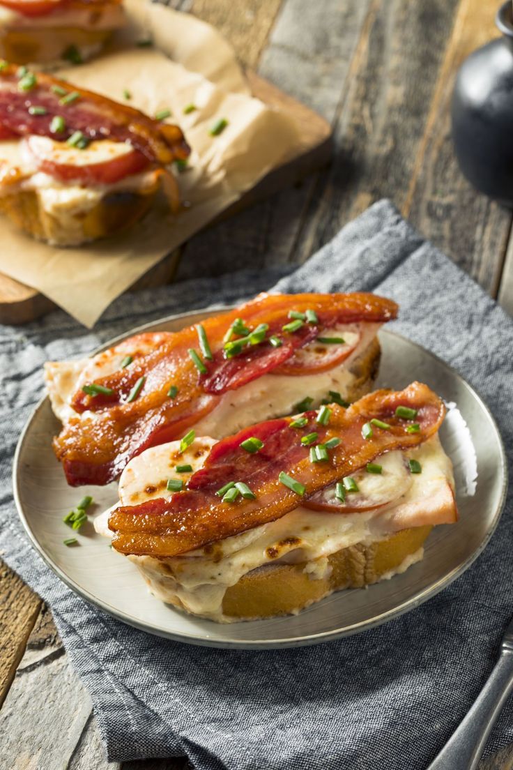 two sandwiches with bacon and cheese are on a plate