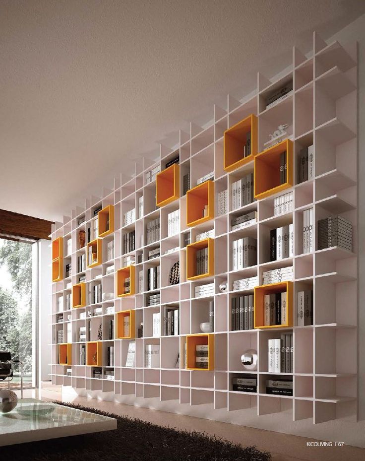 a living room filled with lots of white and yellow bookshelves next to a window