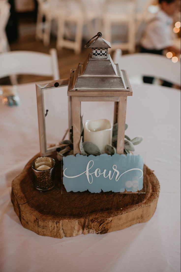 a small wooden lantern on top of a table with a sign that says four above it