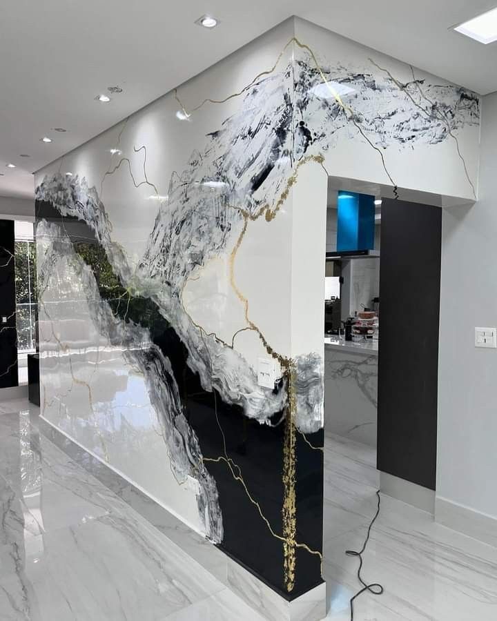 a large marble wall in an office with black and white decor on the walls, along with a gold chain hanging from it's end