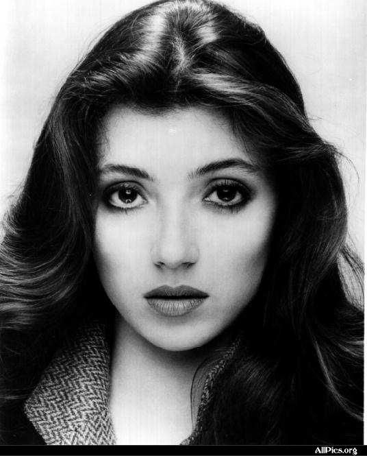 black and white photograph of a woman's face with long hair, wearing a coat