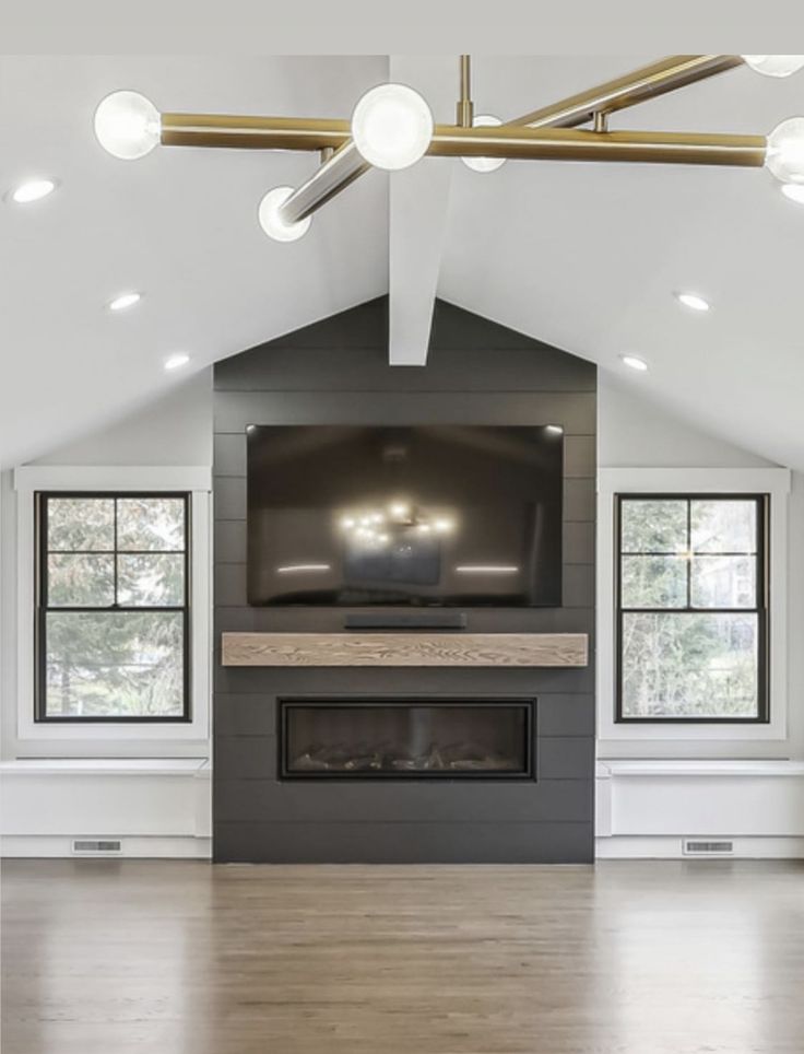 an empty living room with a large flat screen tv on the wall, and wood flooring