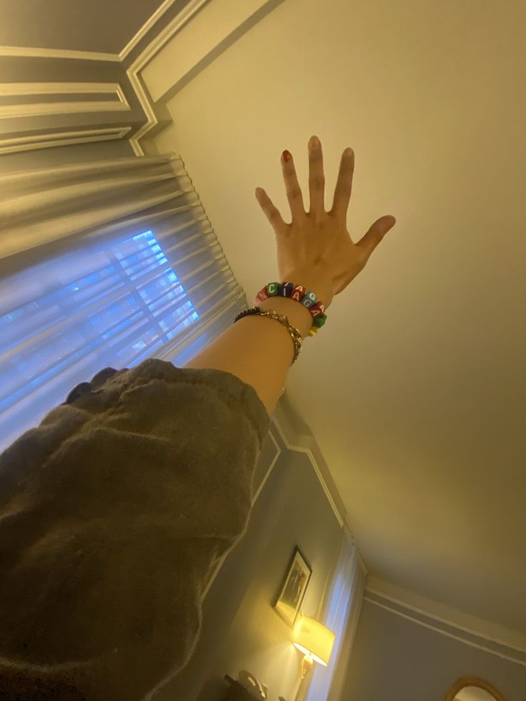 a person's hand reaching up into the air