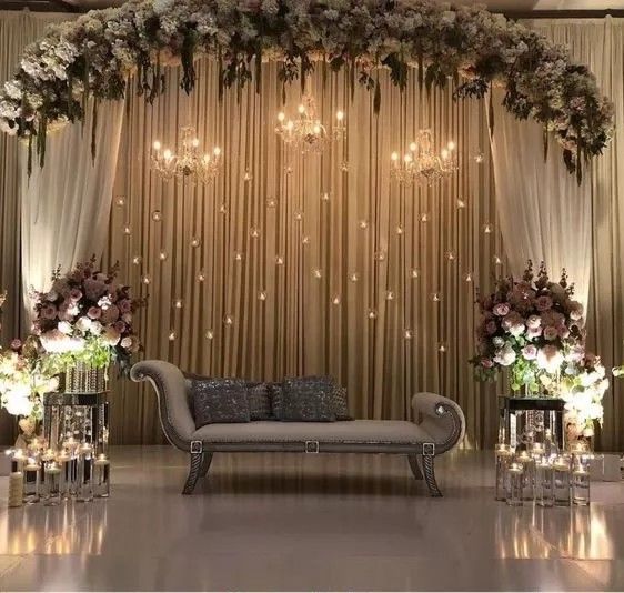 a couch sitting under a chandelier filled with flowers