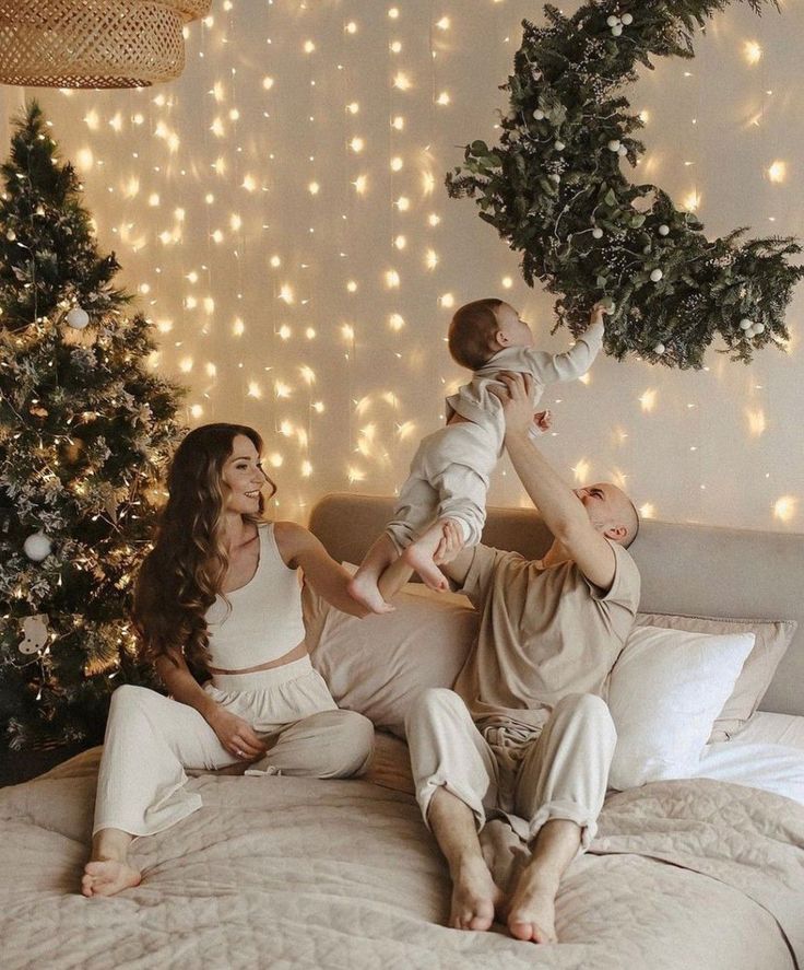 a man and woman sitting on top of a bed with a baby in their arms