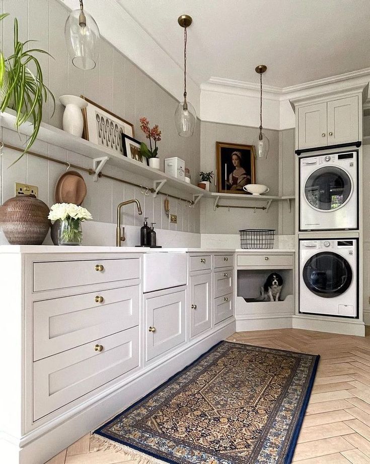 a kitchen with white cabinets and an area rug on the floor in front of washer and dryer