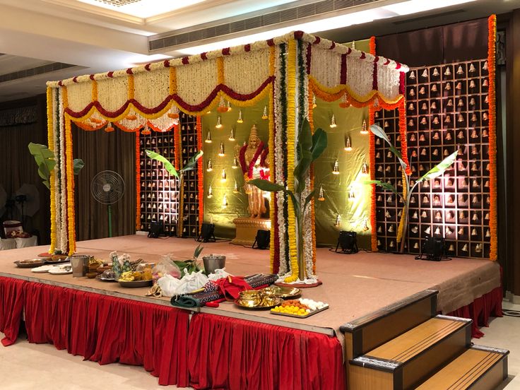 a decorated stage set up with red and yellow draping, gold trimmings and decorations