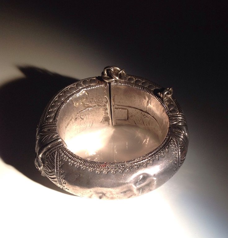 "Spectacular acanthus repousse with geometric borders. Weight is about 96 grams. A handsome example of the craftsmanship of the Indian silversmith during the time of the Raj. Condition is excellent with the heavy patina, wear, and minor dents that I like to see in an antique tribal piece. This bracelet has a small key which is inserted into an open hinge and turned to secure it. The open hinge has an iron pin (probably for strength). Dimensions: 6.75\" in circumference. No bigger wrist will fit. Traditional Oxidized Bracelets For Formal Occasions, Traditional Ceremonial Sterling Silver Bracelet, Traditional Sterling Silver Bracelet For Ceremonial Occasions, Traditional Handmade Sterling Silver Bracelet For Formal Occasions, Traditional Engraved Sterling Silver Bracelet For Formal Occasions, Traditional Engraved Bracelets For Formal Occasions, Traditional Silver Carved Bangle, Ceremonial Silver Cuff Bracelet With Intricate Design, Traditional Carved Silver Jewelry