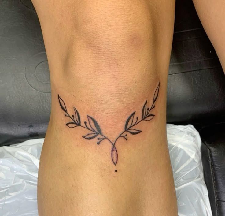 a woman's lower leg with a tattoo on her left side and an arrow in the middle