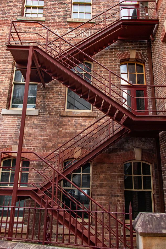 an old brick building with red metal stairs