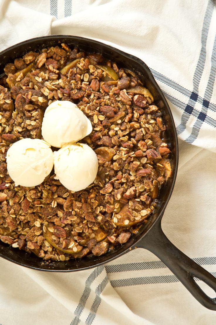 two scoops of ice cream sitting on top of a skillet filled with granola