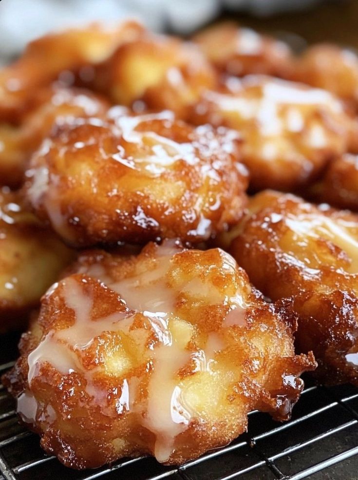 some donuts are sitting on a cooling rack and drizzled with icing