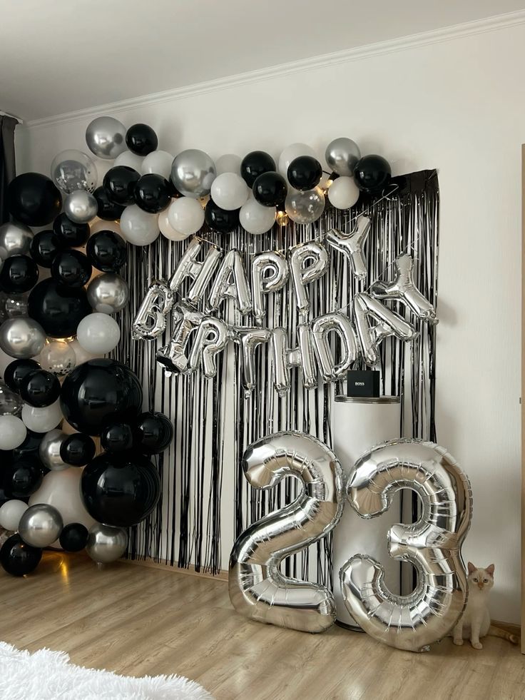 a room decorated with balloons and streamers for a 25th birthday