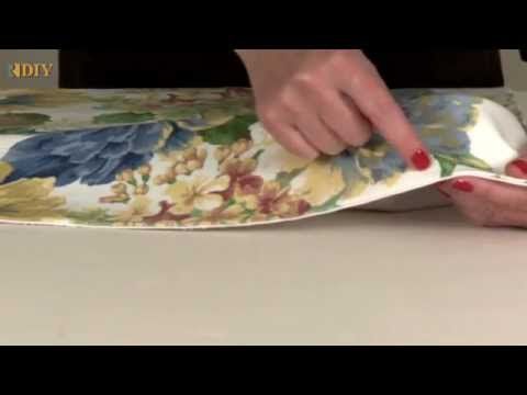 a woman is using a brush to clean the fabric on her chair cushion that has flowers on it