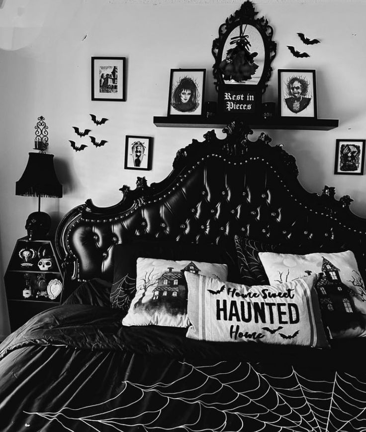 a black and white photo of a bed with halloween decorations on the wall above it