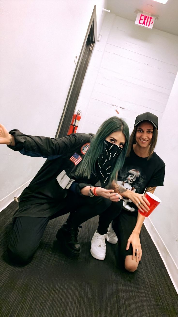 two people posing for a photo in an elevator with their arms around each other and one person pointing at the camera