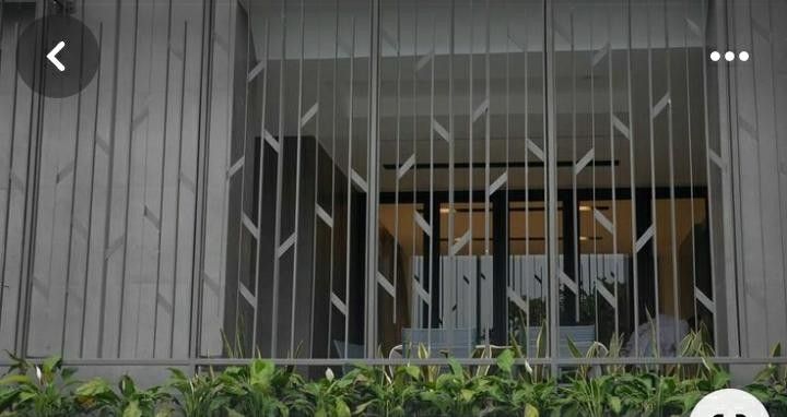 an image of the outside of a building with metal bars and plants in front of it