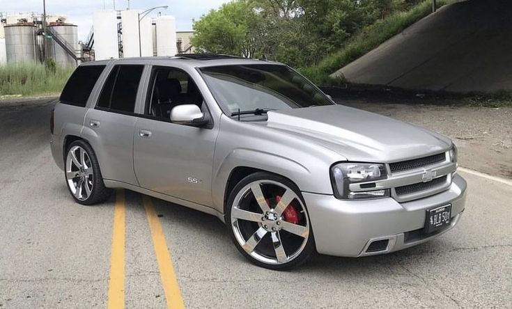 the silver suv is parked on the side of the road