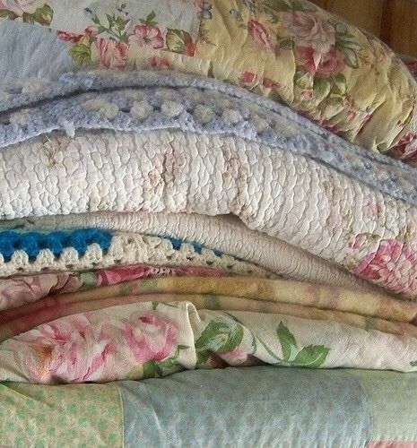 a pile of pillows sitting on top of a bed