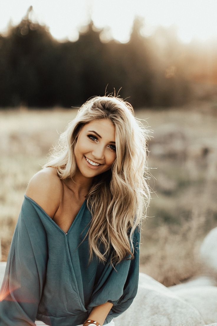 a beautiful blonde woman sitting on top of a white horse