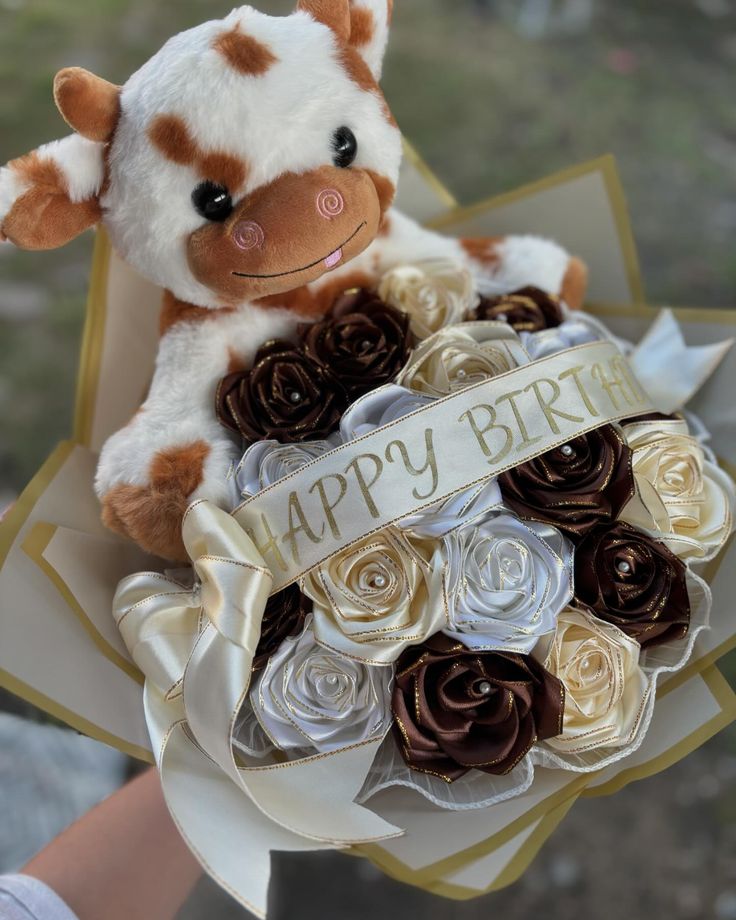 a stuffed cow holding a bouquet of roses in it's hand with the words happy birthday written on it