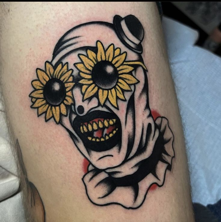 a close up of a person's leg with sunflowers on their head