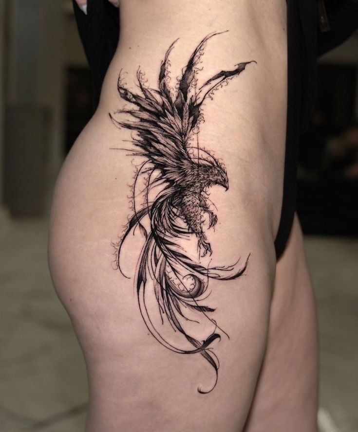 a woman's thigh with a bird tattoo on it