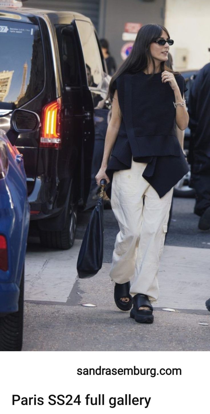 a woman is walking down the street talking on her cell phone and carrying two bags