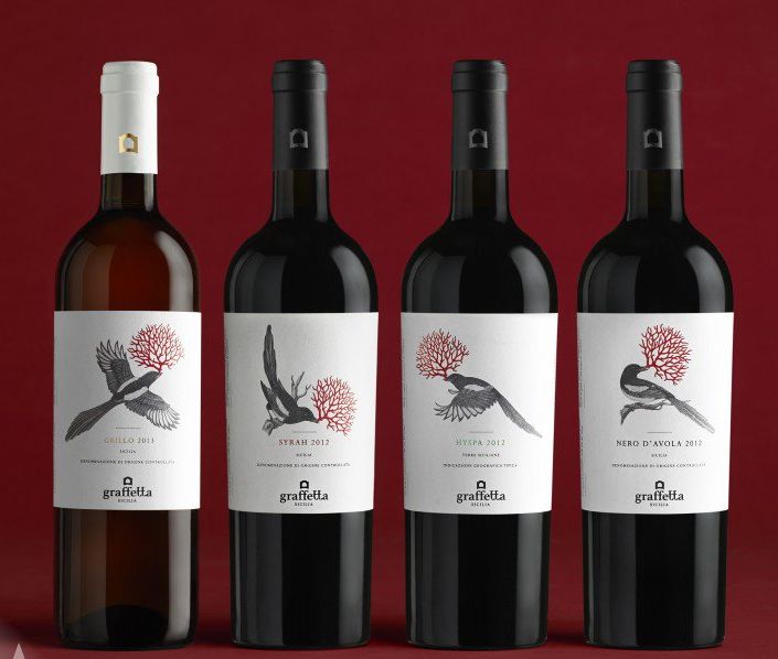 three bottles of wine are shown in front of a red background, one has a bird on it