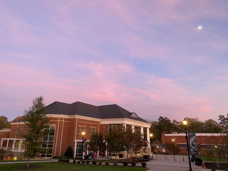 a large building with a clock tower in the middle of it's front yard