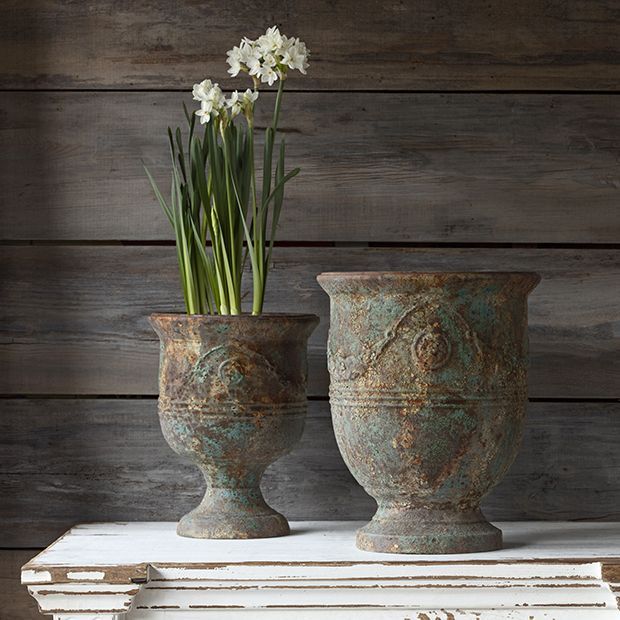 two vases with flowers in them sitting on a table