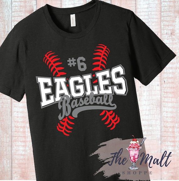 the eagles baseball t - shirt is black with red and white lettering, on a wooden background