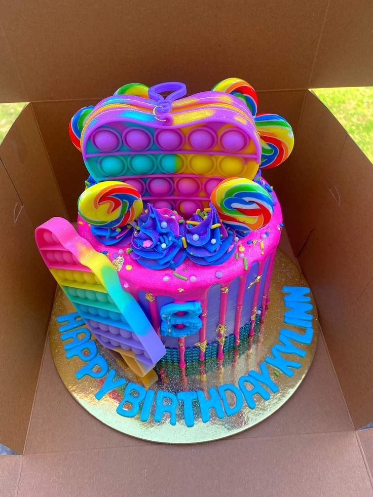 a birthday cake in the shape of a teddy bear with rainbow icing on it