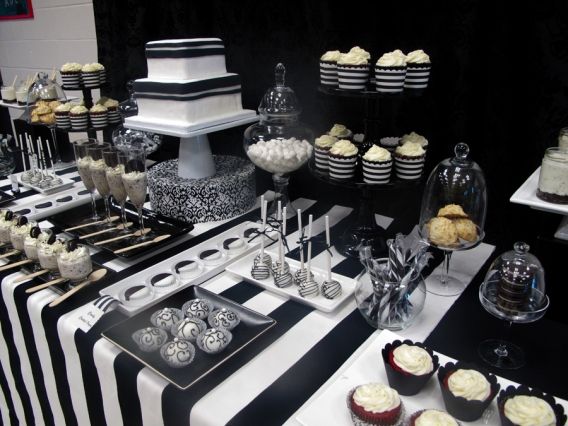 a table topped with lots of cupcakes and cake on top of it's sides