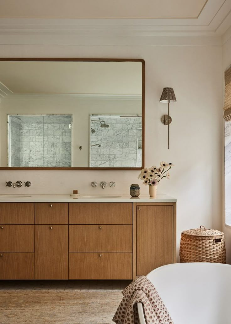 a bath room with a tub and a large mirror on the wall next to it