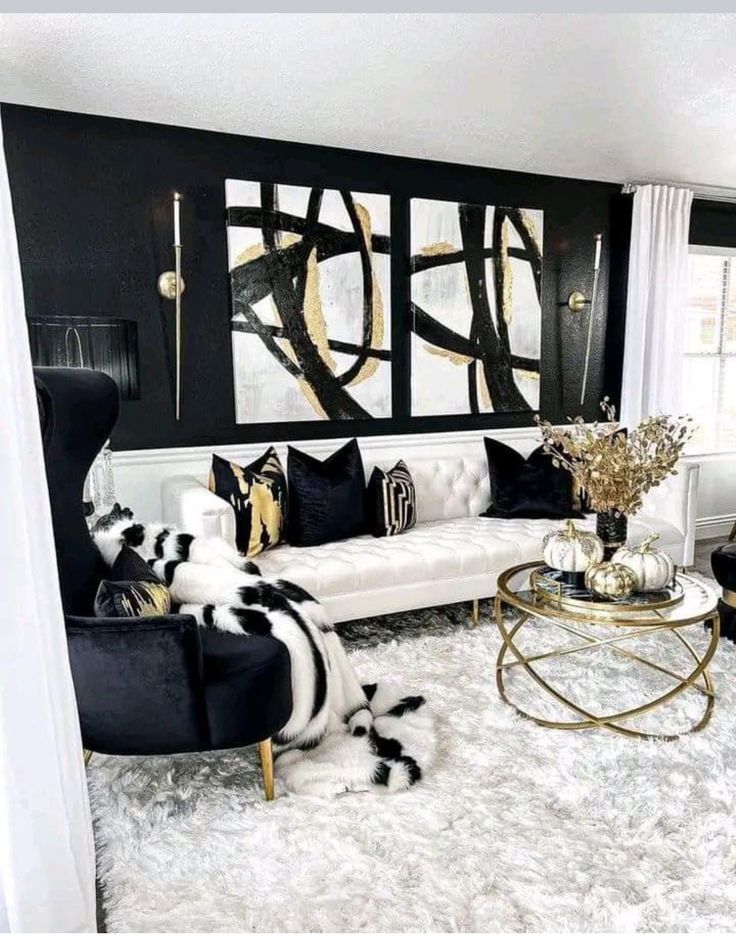 a living room with black and white furniture, rugs and paintings on the wall