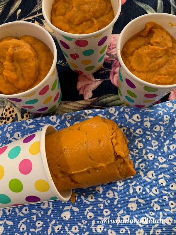 four cups filled with food sitting on top of a blue and white table cloth next to polka dot napkins