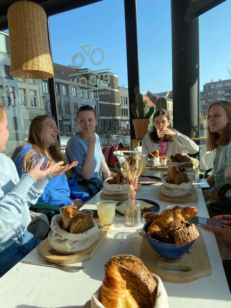 a group of people sitting around a table eating food