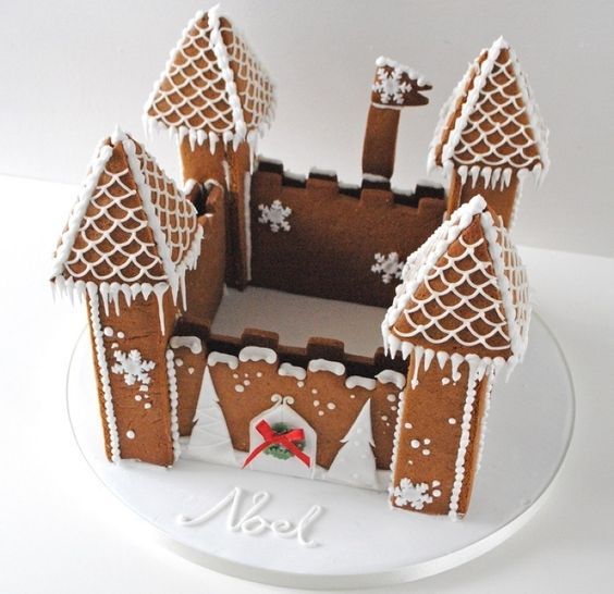 a gingerbread castle is decorated with white icing and snowflakes on it