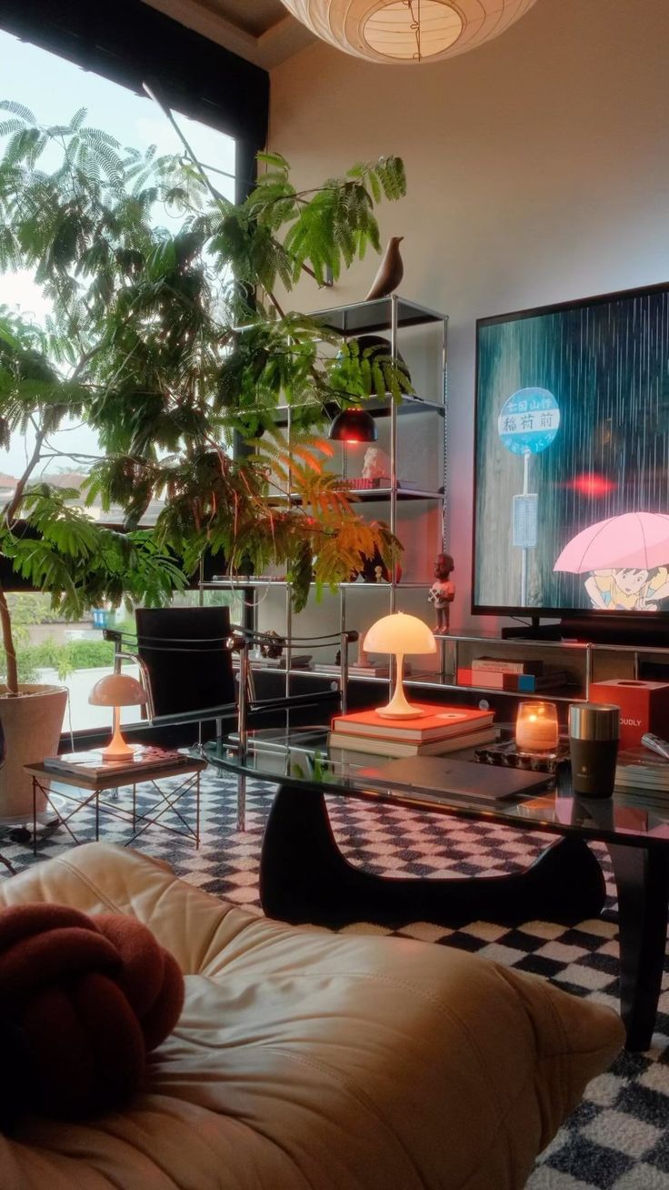 a living room filled with lots of furniture and plants on top of the tables in front of large windows